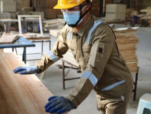 Worker wearing brown reflective coverall, compliant with EN 13688 standards and fire protection requirements, ideal for high-risk work environments.