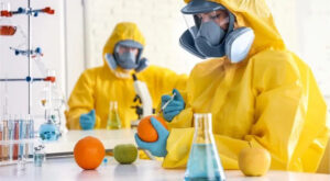 Laboratory workers in chemical PPE conducting experiments.